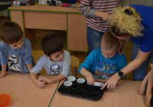 Dzieci z grupy III przygotowują papilotki na babeczki dyniowe