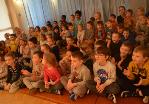 Dzieci z grupy I, II, III, IV oglądają uważnie pokazy żonglerki.