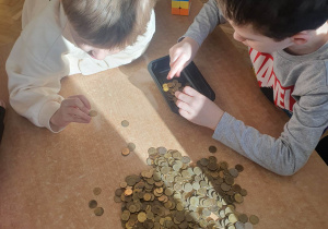 Dzieci z grupy IV z dużym zaangażowaniem segregują monety