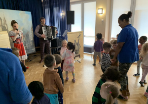 Dzieci tańczą do muzyki granej przez artystów