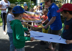 Dzieci z grupy IV przekładają balon z wodą