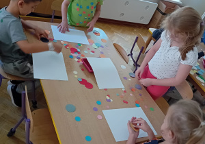 Dzieci z grupy IV przyklejają kropki na kartkę