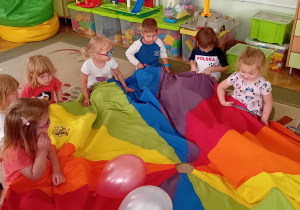 Dzieci z grupy 1 podrzucają balon na chuście animacyjnej