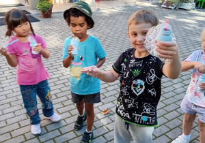 Dzieci z grupy III prezentują samodzielnie wykonane bańki mydlane