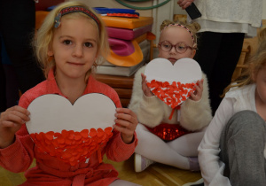 Dzieci z grupy IV prezentują serca w narodowych barwach