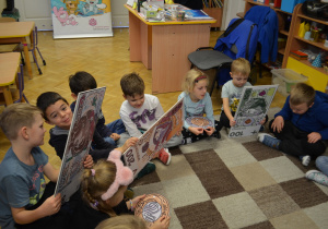 Dzieci z grupy IV siedzą i oglądają banknoty