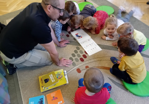 Tata Marcina czyta książkę dzieciom z grupy 1