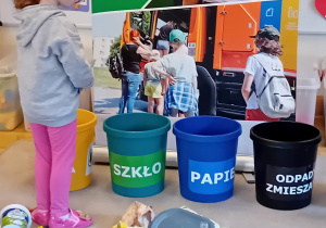 Dzieci z grupy II stoją i segregują śmieci